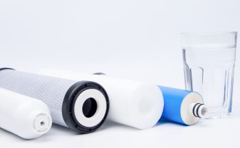 Filtereinsätze für Osmoseanlagen und ein Glas mit klarem Wasser